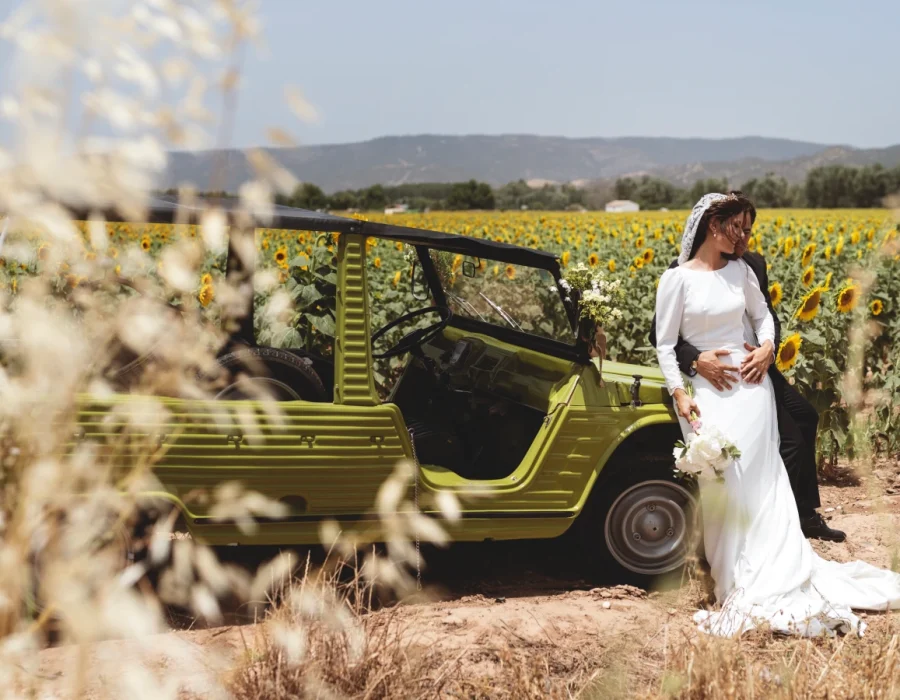 Foto de novios en coche en campo de girasoles